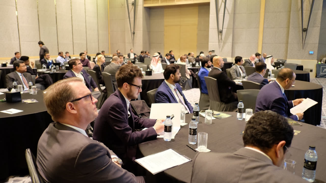 Delegates seated at round tables during a conference session